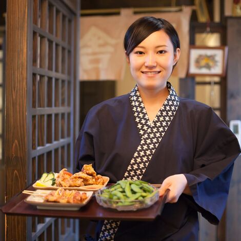 料理を出す女性スタッフ